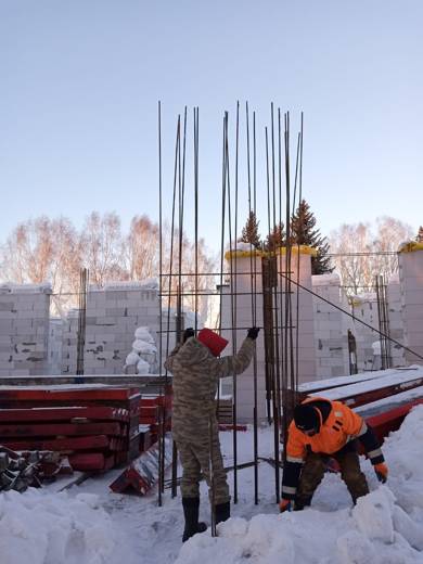 Вязка арматурного каркаса колонны на фоне газобетонных стен