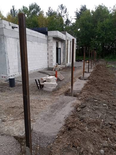 Столбы забора вдоль подъездной дороги, траншея под ограждение