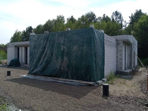 Крыло дома под тентом на время набора прочности бетона